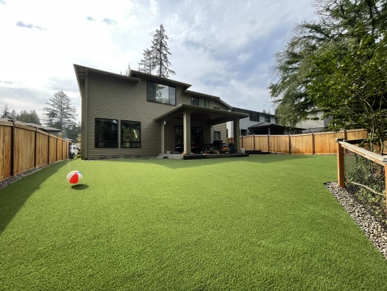 A large fenced in backyard in Kirkland, WA with Pet Friendly synthetic turf installed.